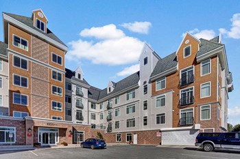 The exterior of the building with uncovered parking for guests and residents Property Image